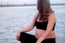 Photo of an expectant mum by the water